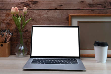 Mock up computer laptop with blank screen and cup of coffee kitchen.の写真素材