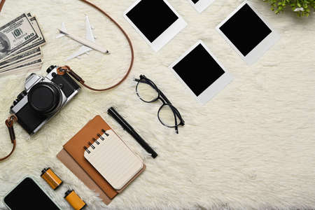 Retro camera, smart phone and travel accessories on wooden background. Travel concept.の写真素材