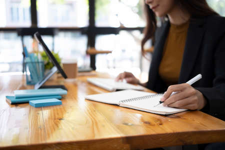Businesswoman checking time on her wrist watch while sitting in office.