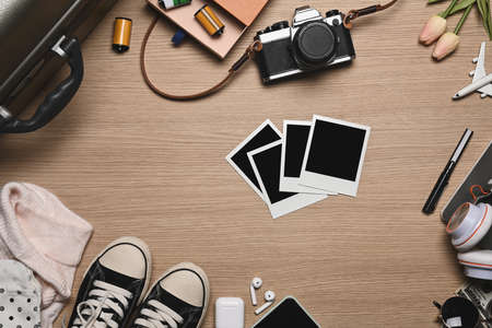 Retro camera, smart phone and travel accessories on wooden background. Travel concept.