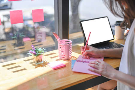 Close up over shoulder view of businesswoman working on laptop computer while sitting in meeting...