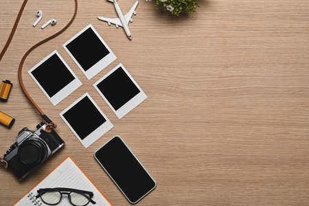 Retro camera, smart phone and travel accessories on wooden background. Travel concept.の写真素材