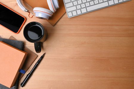Mock up smart phone, headphone, keyboard, coffee cup and notebook on wooden background.の写真素材