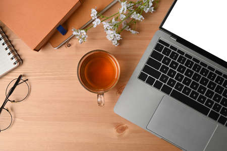 High angle view of simple workspace with smart phone, notebook, sticky note and coffee cup on wooden...