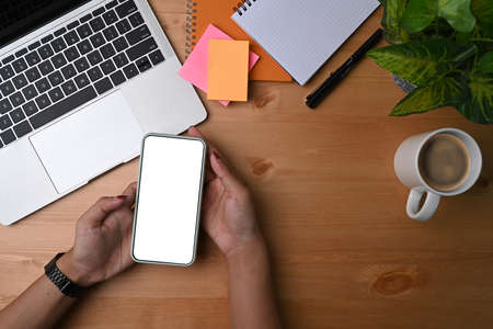 Mock up smart phone, sticky note, coffee cup and notebook on blue background.