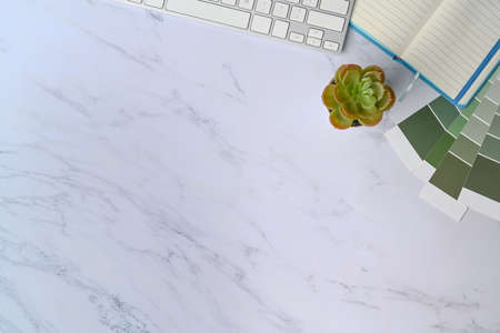 Creative workspace with empty notebook, pen, coffee cup and mobile phone on pink background.の写真素材