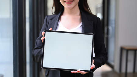 Portrait of successful businesswoman holding pen and writing information on notebook.の写真素材
