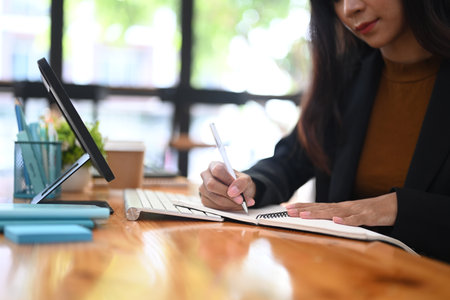 Friendly young woman barista holding and showing digital tablet with empty screen.の写真素材