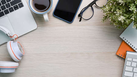 Top view modern workplace with digital tablet, wireless earphone, notebook and coffee cup on wooden...