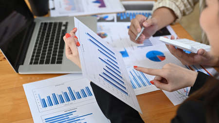 Businesspeople analyzing financial graph on office desk.