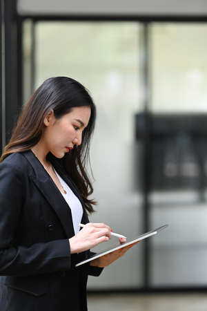 Businesswoman using digital tablet in office room.の写真素材