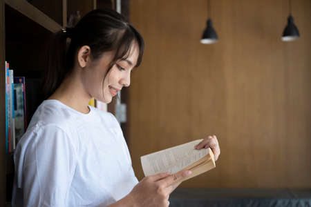 Young woman holding book and smiling to camera.の写真素材