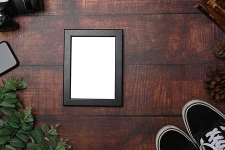 Empty picture frame on wooden background.