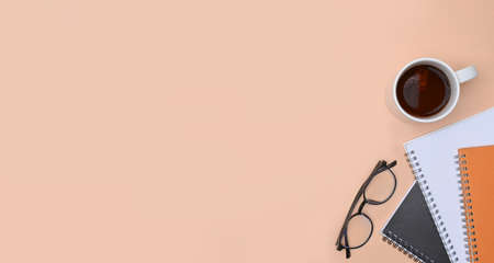 Top view notebook, coffee cup and glasses on beige background.の写真素材