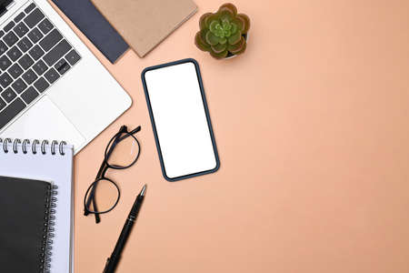 Top view notebook, coffee cup and glasses on beige background.の写真素材