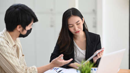 Two businesspeople analyzing financial graph at modern office.の写真素材