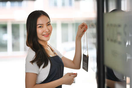 Small business owner turning open sign and ready to service.の写真素材