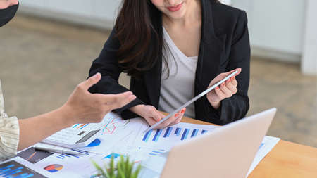 Busy businesswoman standing and working with digital tablet in office room.の写真素材