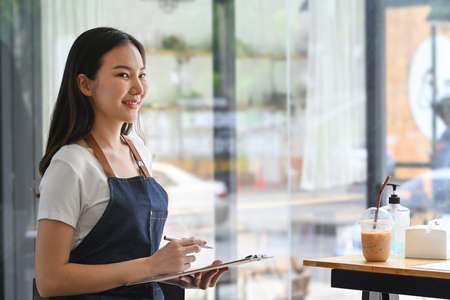 Busy businesswoman standing and working with digital tablet in office room.