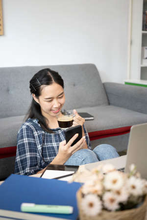 Smiling female resting on sofa and using digital tablet.