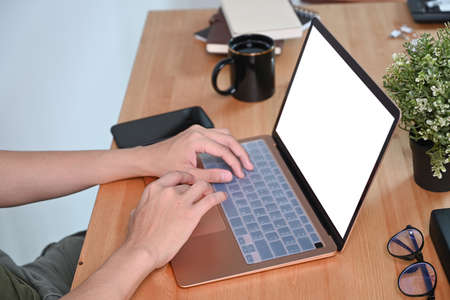 Cropped shot man working with computer laptop at cafe.