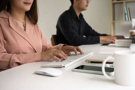 Young businesspeople sitting in modern office and smiling to camera.の写真素材
