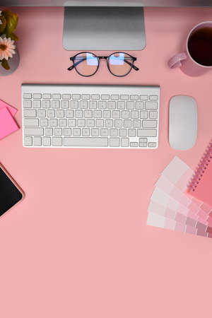 Graphic designer workspace with laptop, smart phone, glasses and notebook on pink background.の写真素材