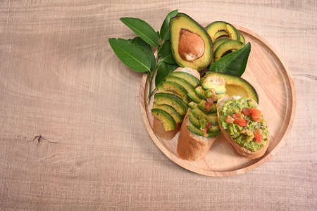 Top view healthy avocado toasts on wooden plate.の写真素材