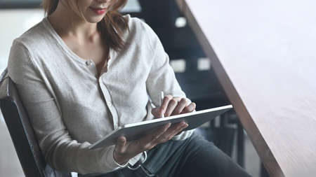 Businesswoman sitting in office and working with digital tablet.の写真素材
