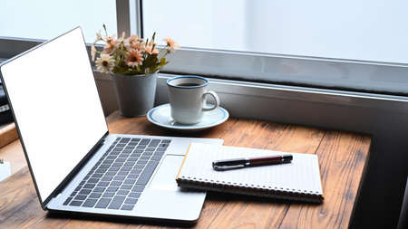 Comfortable workplace with computer laptop, notebook and cup of coffee.の写真素材