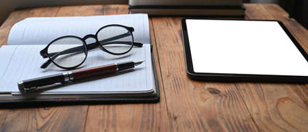 Mock up laptop computer, coffee cup and books on wooden table.の写真素材