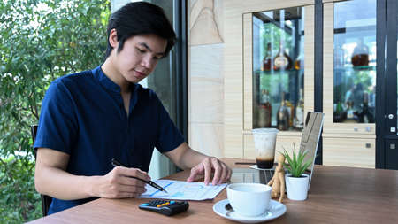 Doctor in protective mask holding stethoscope while standing in hospital.の写真素材