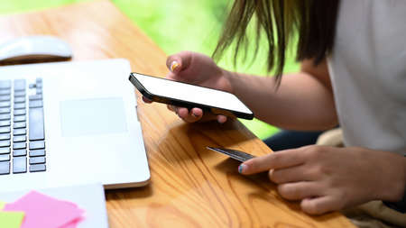 Top view creative designer workspace with smart phone, laptop and color swath.