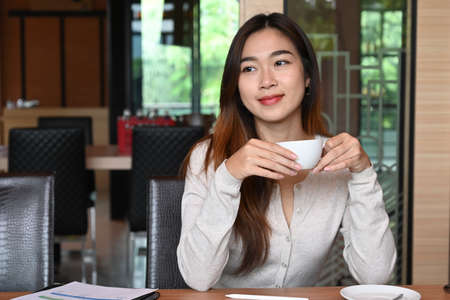 Beautiful businesswoman working with computer tablet and looking at camera.の写真素材