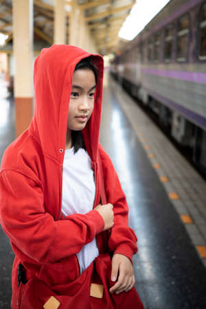 Portrait of Asian girl waiting for the train at railway station.の写真素材