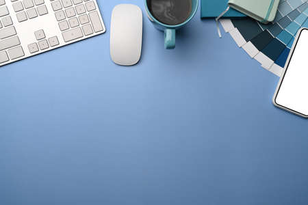Mobile phone, coffee cup and color swatch on designer workspace.