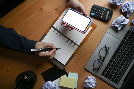 Top view female working with laptop and making note on notebook.の写真素材