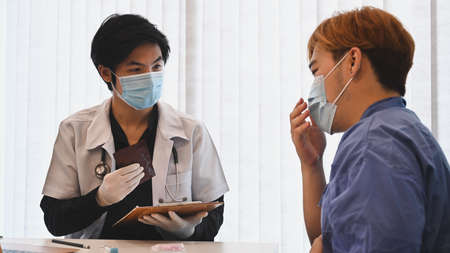 Young man patient having consultation with doctor in hospital.の写真素材