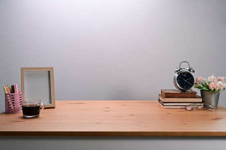 Comfortable workspace with computer tablet, books and coffee cup on wooden desk.の写真素材