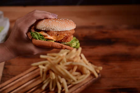 Homemade burgers with fried potatoes and glass of soft drink on wooden table.の写真素材