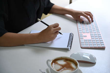 Businessman holding notepad and working with laptop.の写真素材