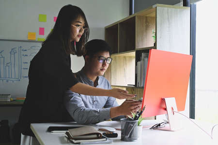 Businesspeople analyzing charts and market reports together at modern office.