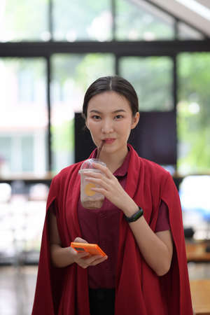 Smiling woman using mobile phone at office.の写真素材