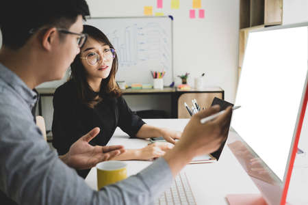 Business people discussing and analyzing financial graphs on whiteboard together in office.の写真素材