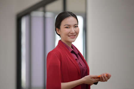 Happy businesswoman talking on mobile phone while sitting in office.