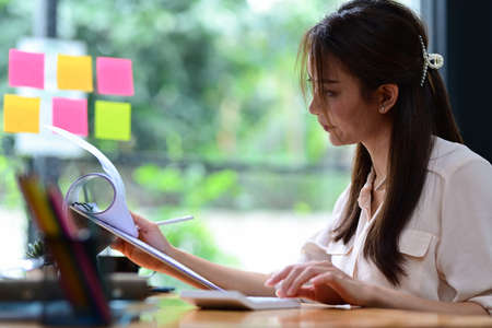 Side view woman working online with computer laptop at cafe.の写真素材