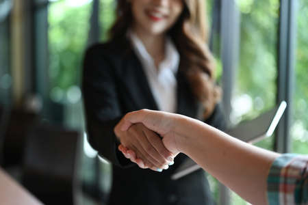 Business people shaking hands on a business cooperation agreement in modern office.の写真素材