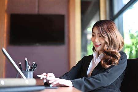 Businesswoman holding stylus pen and writing on digital tablet.の写真素材