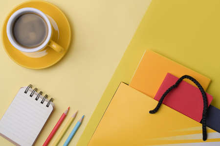 Stationery, notebook, coffee cup and bag on yellow background.の写真素材