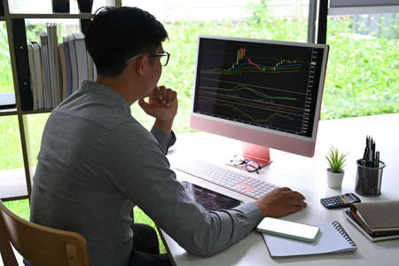 Businessman analyzing stock market investment on computer at office.の写真素材